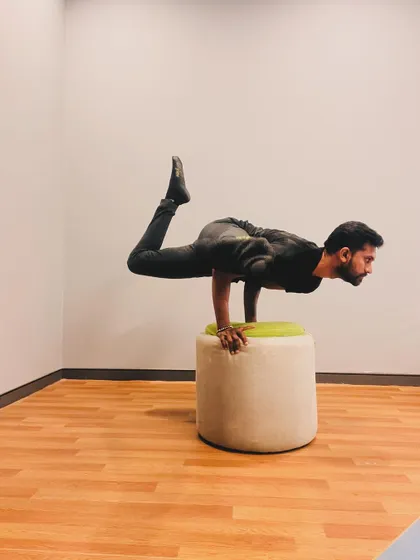 Finding stability in this elevated arm balance. The key is to press firmly into the hands and engage the core to lift the hips.