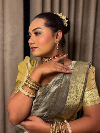 A side profile showing the traditional hairstyle with flowers (gajra) and jewelry for a South Indian themed event. It's all about authenticity.