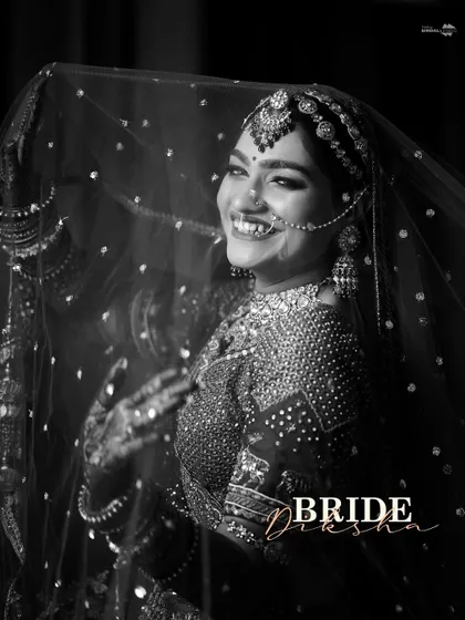 A beautiful black and white portrait of the bride, Diksha, smiling through her veil. The contrast and her happy expression make this a captivating shot.