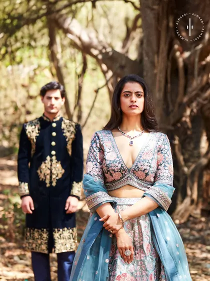 Here you can see how the groom's outfit subtly picks up on the colors of the bride's lehenga. It's these little details that make a couple's look cohesive.
