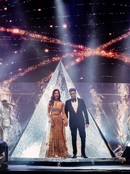 A powerful pose to mark the beginning of their performance. The couple stands on a custom-built pyramid stage, flanked by dancers and framed by pyrotechnics, ready to kick off their sangeet night.