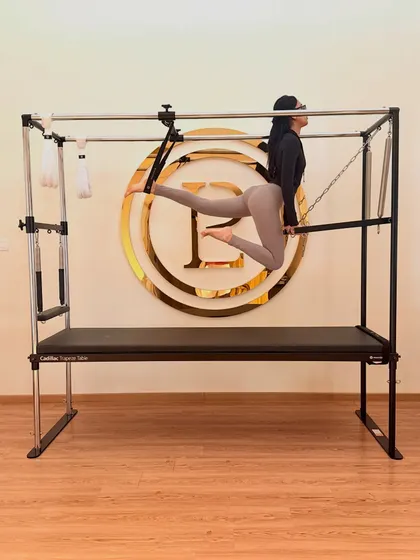 Using the push-through bar on the Cadillac for a graceful leg series. This exercise sculpts the glutes and hamstrings while challenging your balance and core.