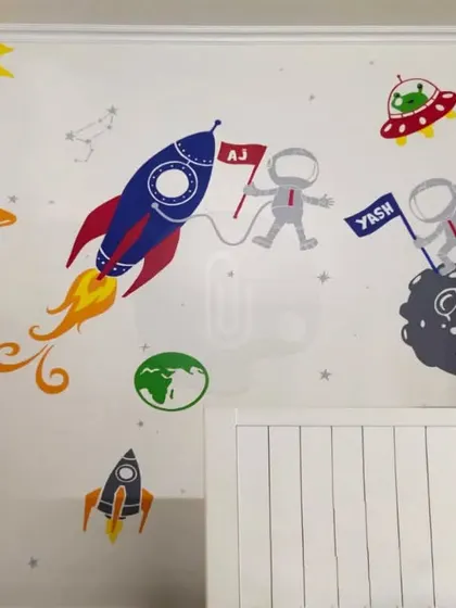 A fun and colorful space-themed mural for a kid's room in Gurgaon. We included personalized flags with the children's names, making the artwork extra special for them.
