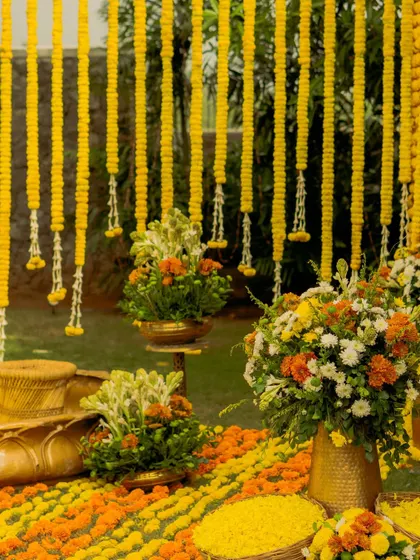 The seating area for the haldi, featuring brass urlis and baskets filled with fresh flower petals. Every element is chosen to contribute to a cohesive, warm, and traditional aesthetic.