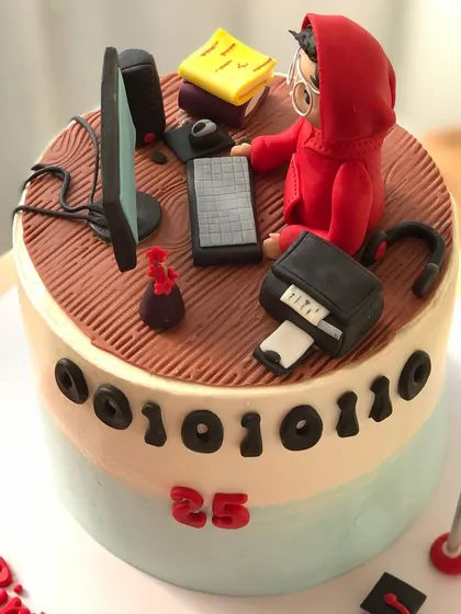 A cake for a coder or hacker, featuring a "Money Heist" inspired figure, a computer setup, and binary code.