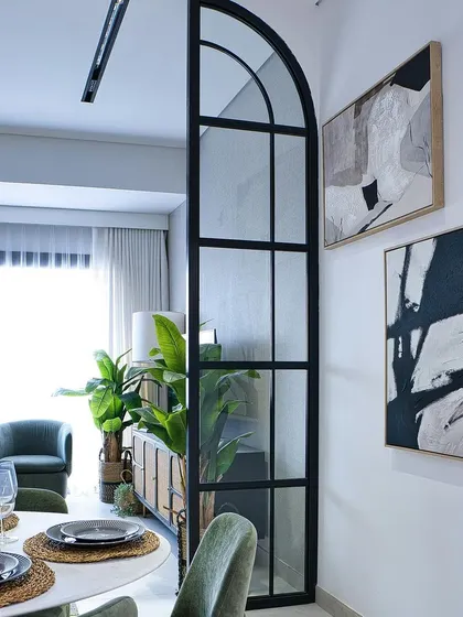 Abstract art and indoor plants add life and personality to this elegant dining and living space.