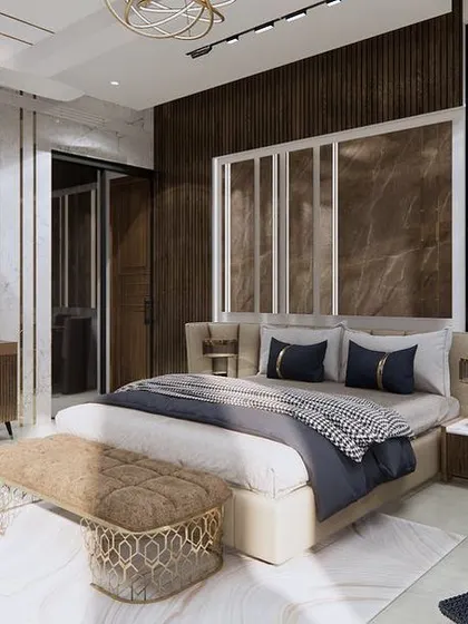 A serene master bedroom design where comfort meets style. The room features a large window for natural light, a plush upholstered bed, and a mirrored wall panel that enhances the sense of space and luxury.