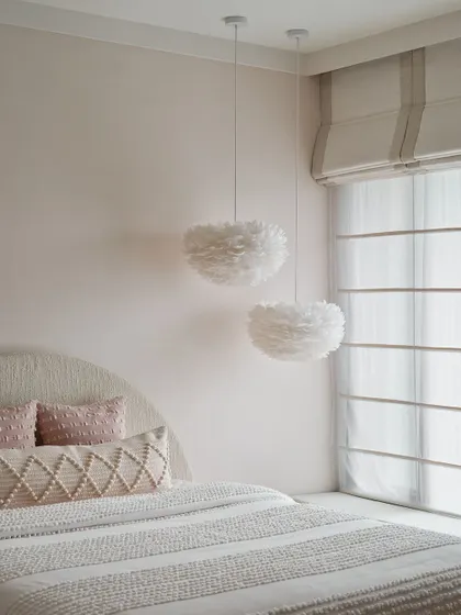 We used soft, feathery pendant lights in this bedroom to add a touch of whimsy and texture. The color palette is kept minimal and muted, creating a serene and dreamy atmosphere.