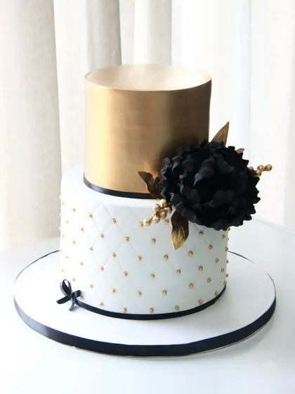 A bold and beautiful cake for a 50th birthday celebration. I paired a quilted white fondant tier with a metallic gold top tier, accented with a dramatic handmade black sugar flower.