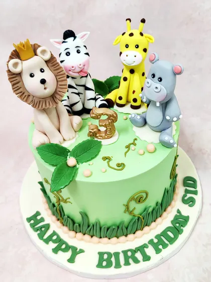 We gather the whole jungle crew for this vibrant safari cake. A crowned lion, a cheeky zebra, a friendly giraffe, and a happy hippo are handcrafted to sit atop a lush green cake, perfect for a wild animal-themed birthday adventure.