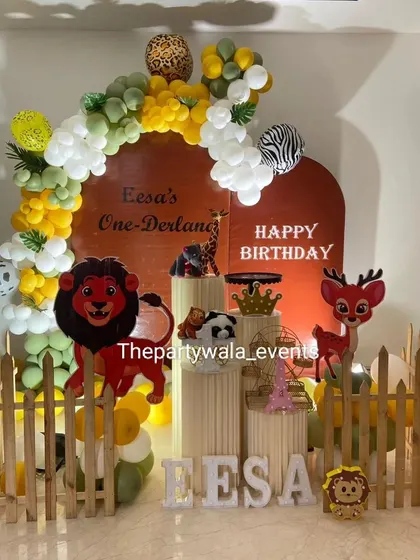 A "One-Derland" jungle theme with a unique terracotta-colored backdrop. The yellow, white, and green balloons complement the earthy tones perfectly.
