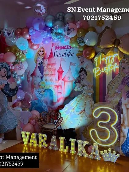 An enchanting princess setup for Varalika's 3rd birthday. This decoration is filled with cutouts of various princesses, a castle backdrop, and beautiful lighting effects.