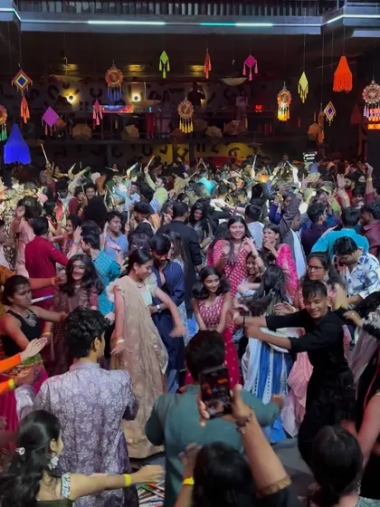 The dance floor is a whirlwind of color and movement. I curate my music to build the energy, from traditional beats to high-energy Bollywood Dandiya tracks.