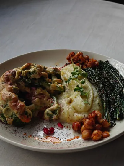A hearty tapas plate with grilled vegetables, mashed potatoes, and crispy kale.