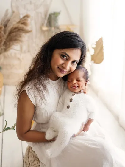 Just look at that dimple! A mother holds her smiling newborn, and his little dimple is the star of the show. So much personality in such a tiny person.