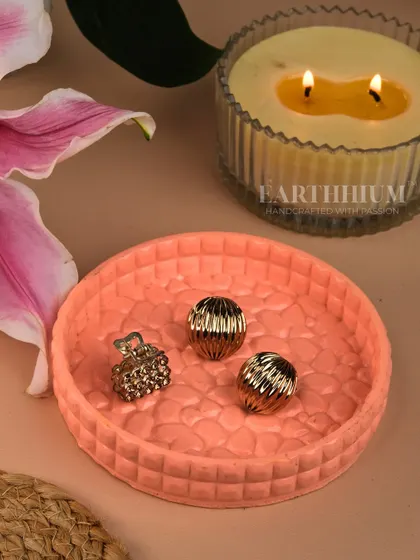 This round, peach-colored Jesmonite tray has a textured surface and is perfect for holding jewelry, keys, or other small treasures. It can also serve as a beautiful base for a candle.