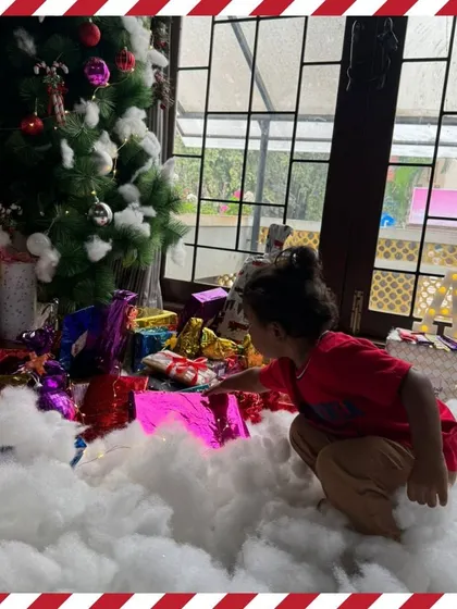 A toddler reaches for a gift, captivated by the bright colors and promise of a surprise.