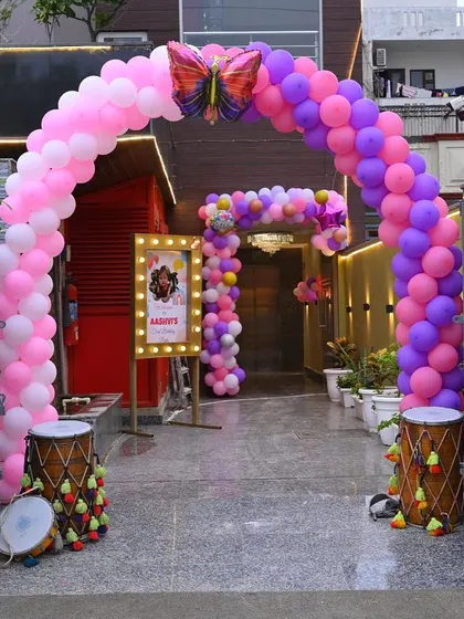 A beautiful balloon arch marks the entrance to this outdoor venue, setting a festive mood for the butterfly-themed party inside.