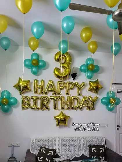 A simple home decoration with a "Happy Birthday" foil banner and helium balloons.