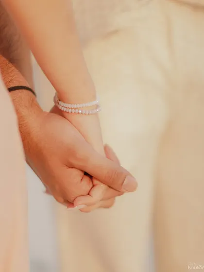A close-up detail shot of the couple holding hands, symbolizing their connection and promise. These small details are a big part of the story.