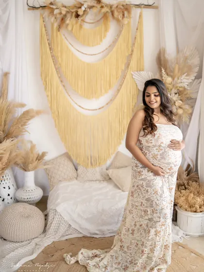 A beautiful solo portrait of the mom-to-be in a delicate lace gown. The neutral tones of the dress and the boho backdrop create a soft and timeless look.