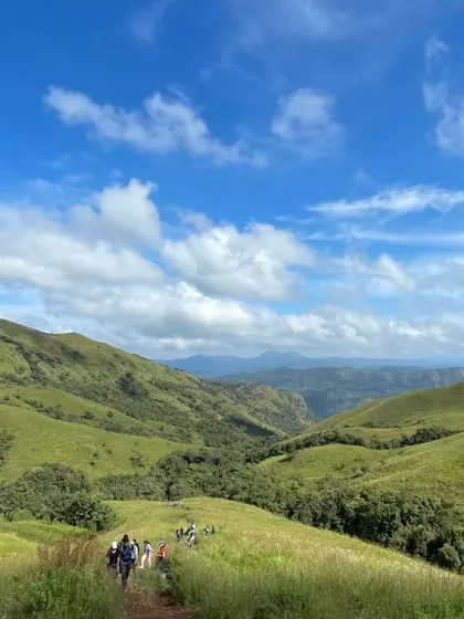 A wide angle view of the trekking group making their way down the green slopes of Nethravathi.