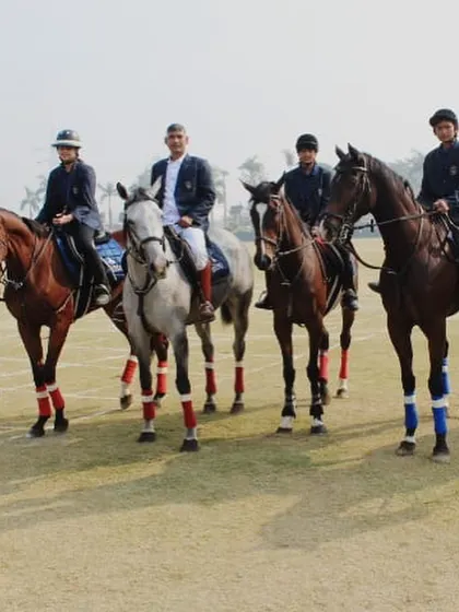 A formal group portrait of our riders and instructors on horseback, dressed in competition attire.