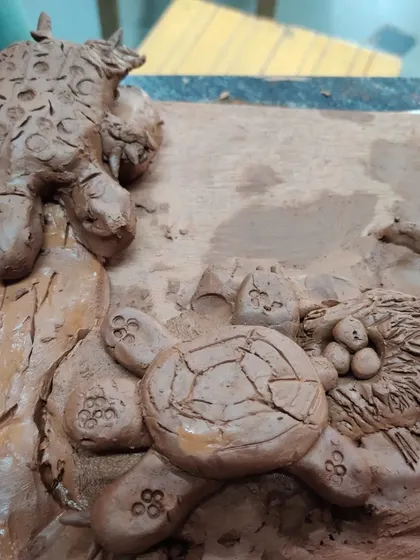 A detailed clay scene featuring a turtle laying its eggs in a nest. This piece shows incredible attention to detail and storytelling from a young artist during a nature themed clay workshop.