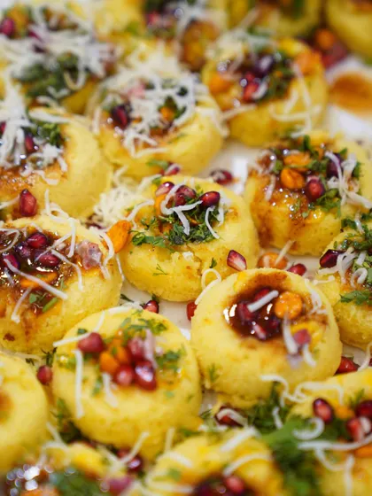 Food crafted with care. A beautiful close-up of our Surti Ghari, a traditional sweet, garnished with pomegranate and sev.