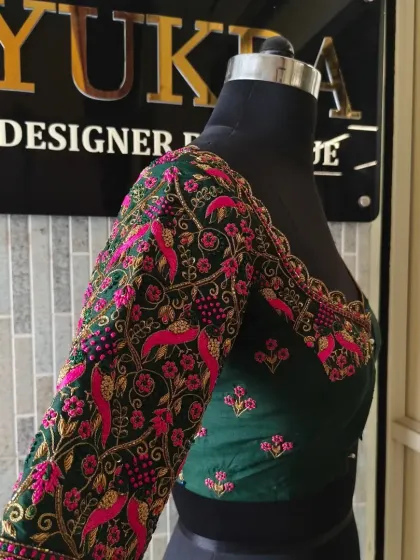 This view highlights how the embroidery extends seamlessly from the sleeve to the body of the blouse, creating a cohesive and luxurious design.