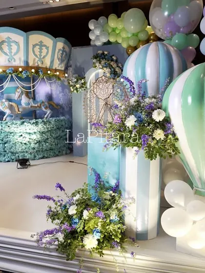 A closer look at the carnival stage, showing the detailed carousel backdrop and the beautiful floral arrangements.