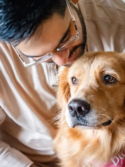 A close-up shot of a man sharing a tender moment with his Golden Retriever, showing the deep bond that exists across the whole family.