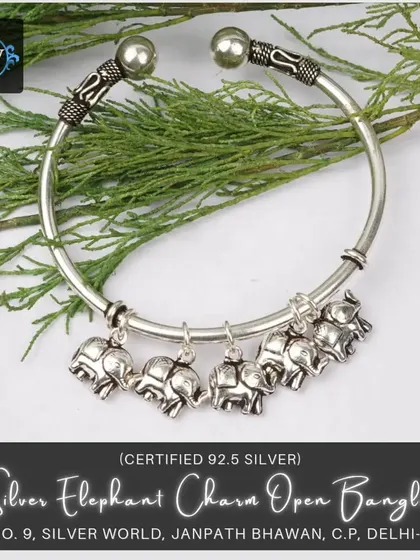 This twisting open bangle features adorable elephant charms. It's a lucky and playful accessory, perfect for adding a touch of ethnic fun.