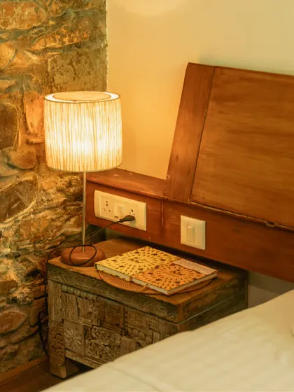 Every corner tells a story. This cozy bedside setup with a rustic chest and warm lamp is perfect for unwinding with a book after a day of exploring.
