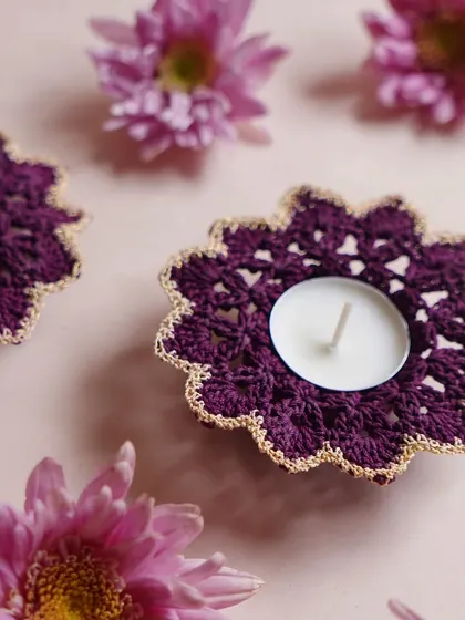 A detailed look at our purple flower-shaped diya coaster with a shimmering gold border. We can customize the colors to match your rangoli or home decor theme for a fully coordinated celebration.