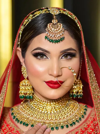 A stunning close-up of a classic red bridal look. The eyes are defined with a sharp wing and subtle shading, balanced by a bold red lip.