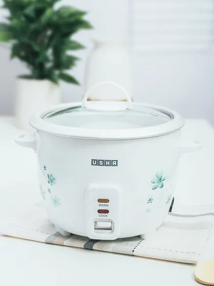 A lifestyle shot of an Usha rice cooker in a clean, bright kitchen setting. Placing the product in a realistic environment helps customers visualize it in their own homes.