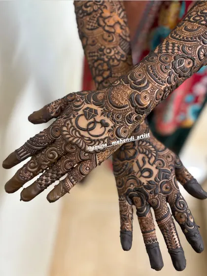 A classic engagement mehendi with the couple's initials 'VS' and a ring motif. The surrounding patterns are dense and traditional, perfect for a grand celebration.