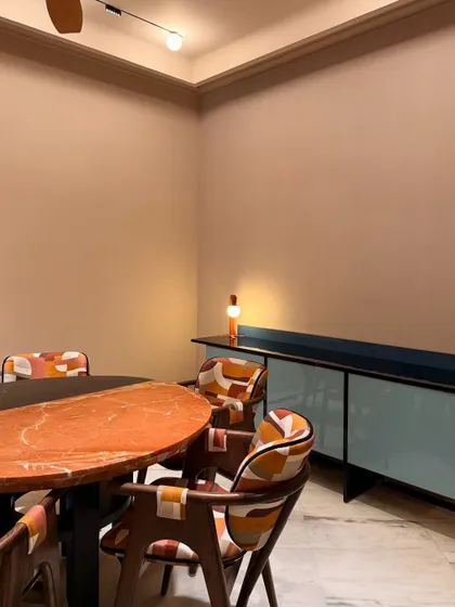 A closer look at the "Terra & Tide" dining area, highlighting the contrast between the patterned chairs, the unique table, and the sleek, light blue sideboard.