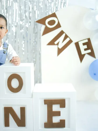 Standing tall and proud. This shot captures that exciting pre-toddler stage, full of curiosity and new abilities, against a festive birthday backdrop.