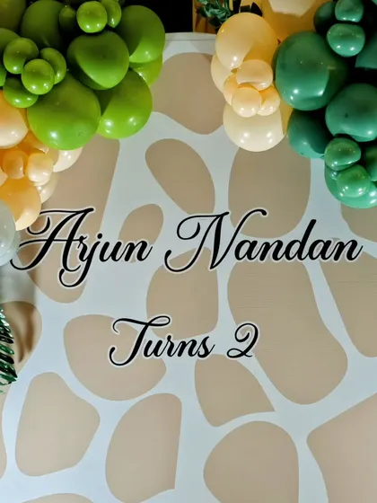 The custom name and number backdrop for Arjun's second birthday safari party.