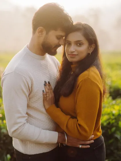 A tender moment captured in a sun-drenched field. We use the golden hour light to create a warm, romantic glow, highlighting the couple's affection in this beautiful pre-wedding photograph.