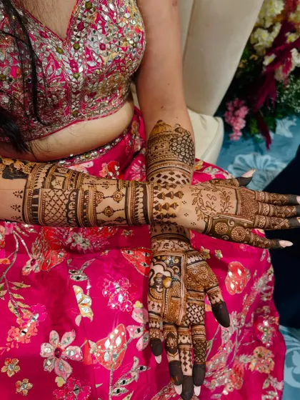 A beautiful shot of a bride's crossed arms, showcasing the symmetry and detail of her full-coverage mehendi.