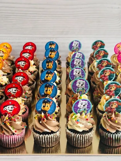 This large order of Paw Patrol themed cupcakes is perfect for a big birthday bash. I've arranged the cupcakes by character, including Chase, Marshall, and Skye, each with a custom paper topper and colorful sprinkles on a swirl of ombré buttercream.