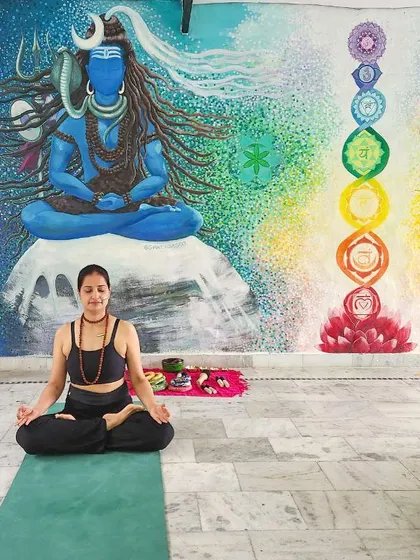 Finding my center in Rishikesh. Here I am in Padmasana (lotus pose) in front of a beautiful mural of Lord Shiva and the seven chakras, connecting to the spiritual energy of this sacred place.