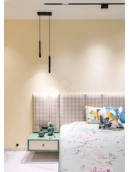 In this master bedroom, we used a soft green and white color palette to create a fresh and airy feel. The floating nightstand with a patterned headboard and minimalist pendant lights adds a touch of modern elegance.