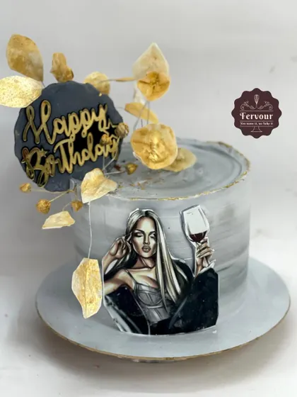 A modern and artistic birthday cake with a grey marble effect and gold accents. The design is inspired by a Pinterest photo and customized for the client, featuring a stylish illustration and wafer paper leaves.