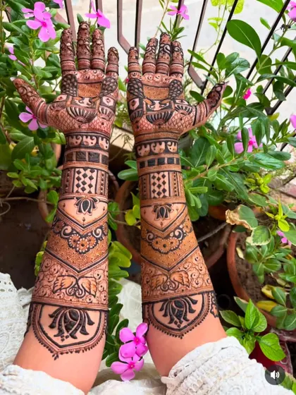 This design combines geometric jaali patterns with soft lotus and elephant motifs. The V-shape on the forearm creates a modern and elegant silhouette.
