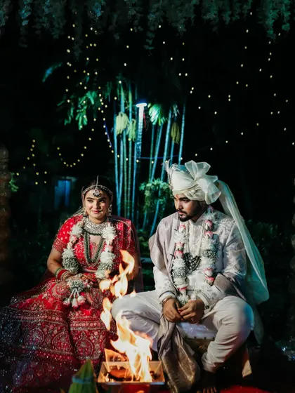 The sacred fire or 'agni' is central to a Hindu wedding. We capture the couple in this serene, traditional setting, with the warm glow of the fire lighting their faces.
