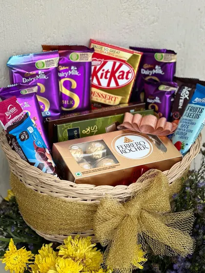 Another angle of the overflowing chocolate gift basket, decorated with a gold bow.